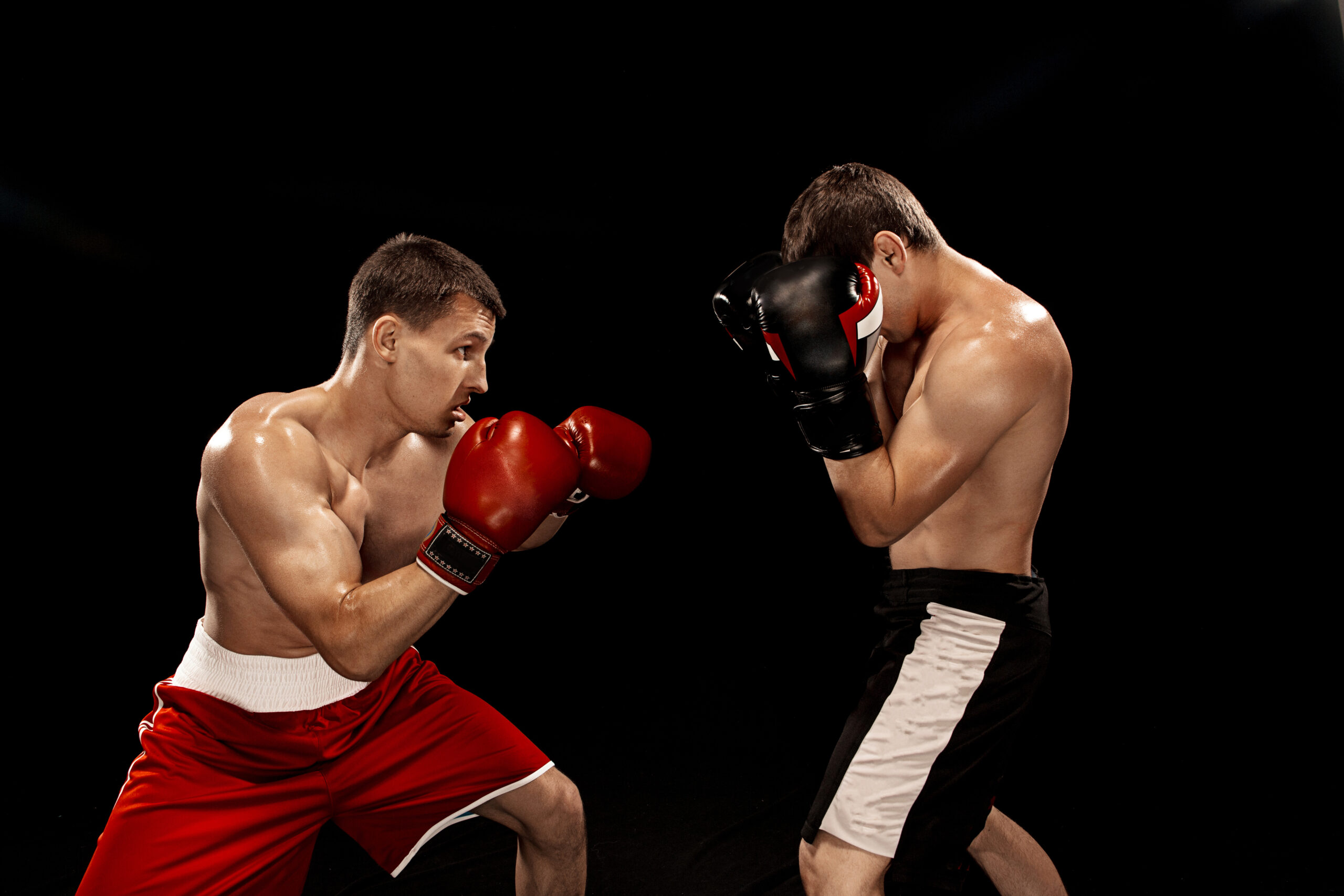 Two professional boxer boxing on black studio background.